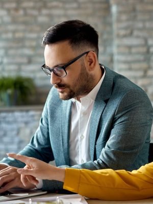 Advisor and client reviewing financing fees and terms together on a laptop screen during a property consultation in France